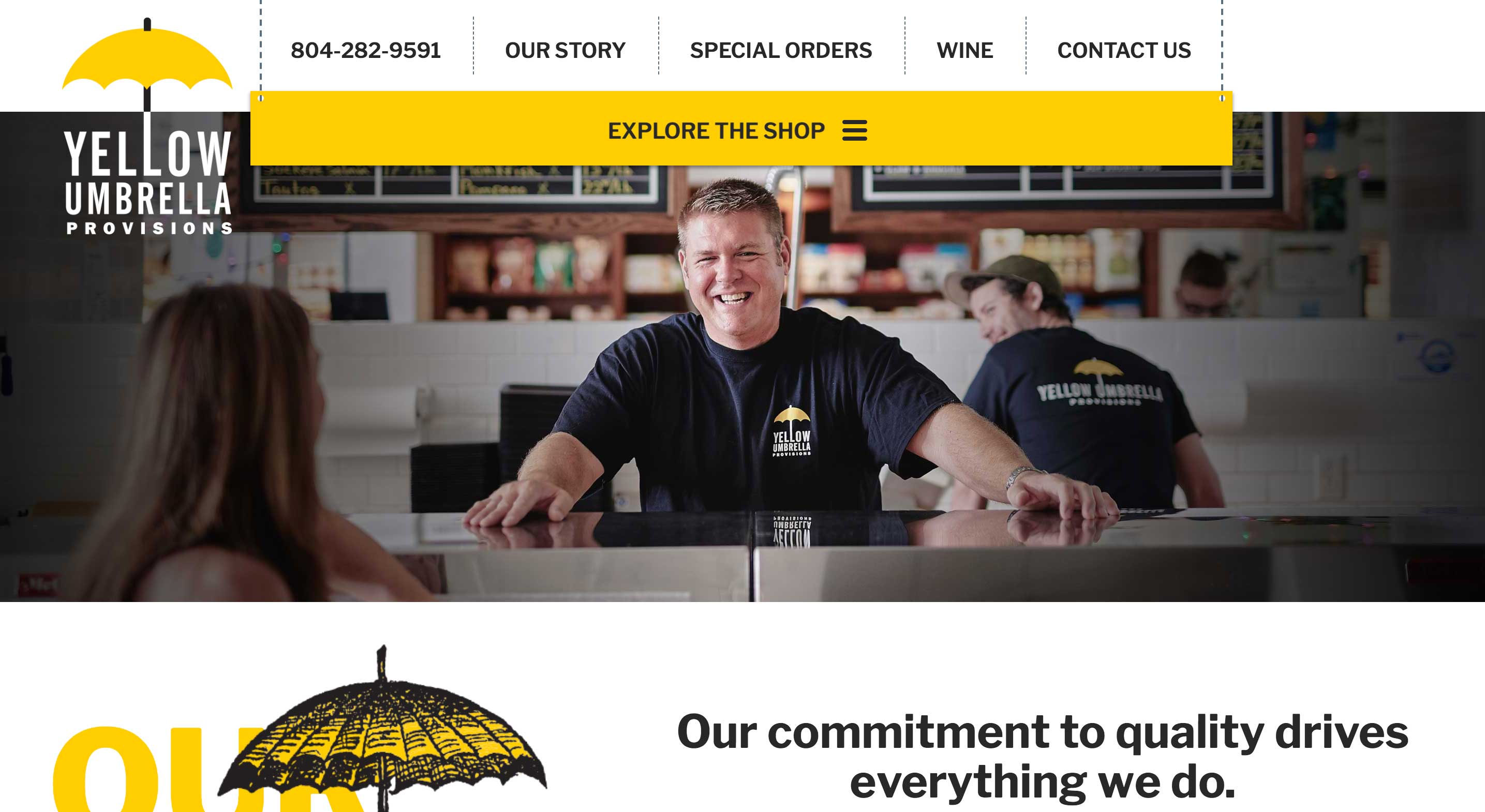 A man standing behind the counter of the Yellow Umbrella shop smiles as a customer approaches